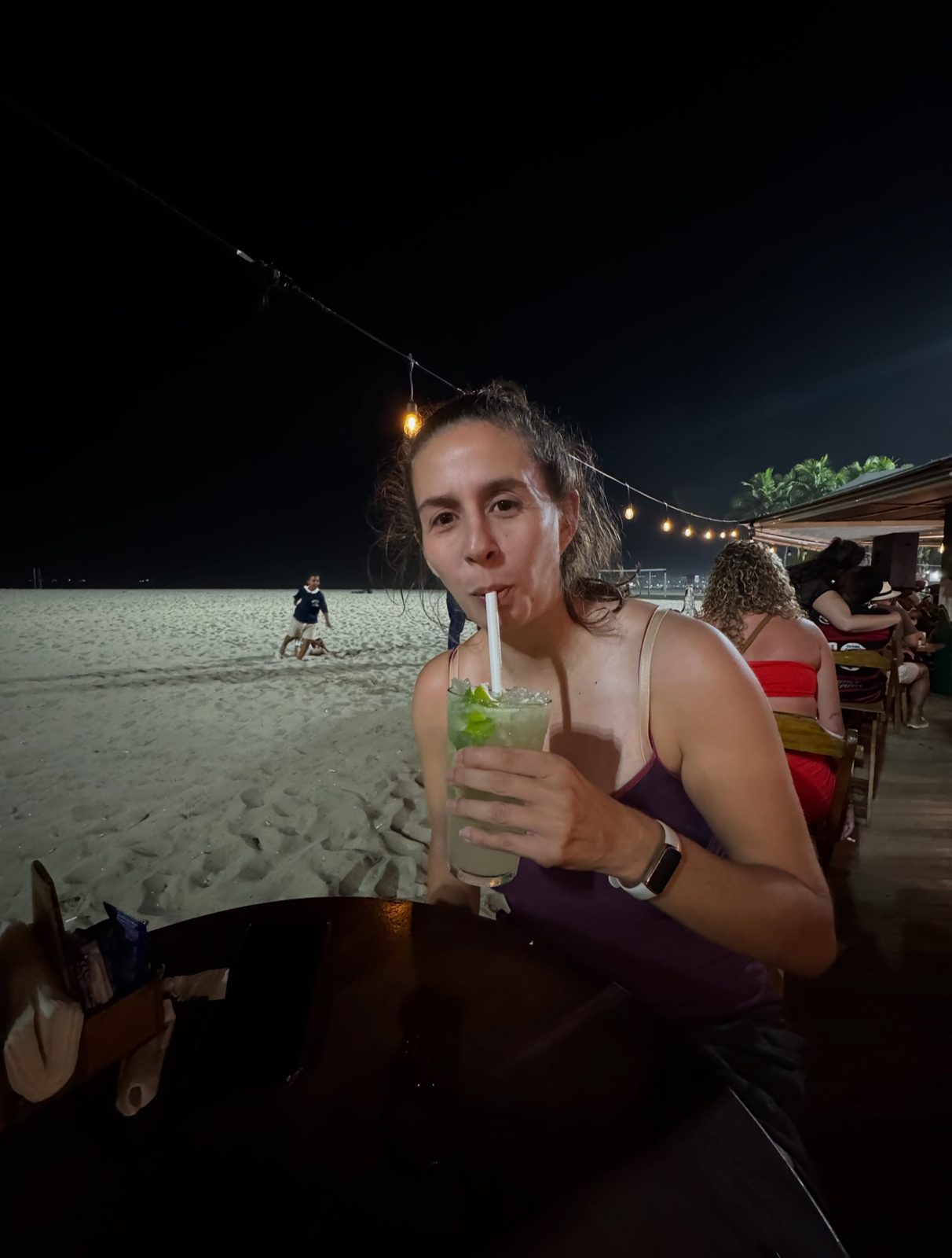 Mirjam mit einem Caipirinha in einer Strandbar am Abend