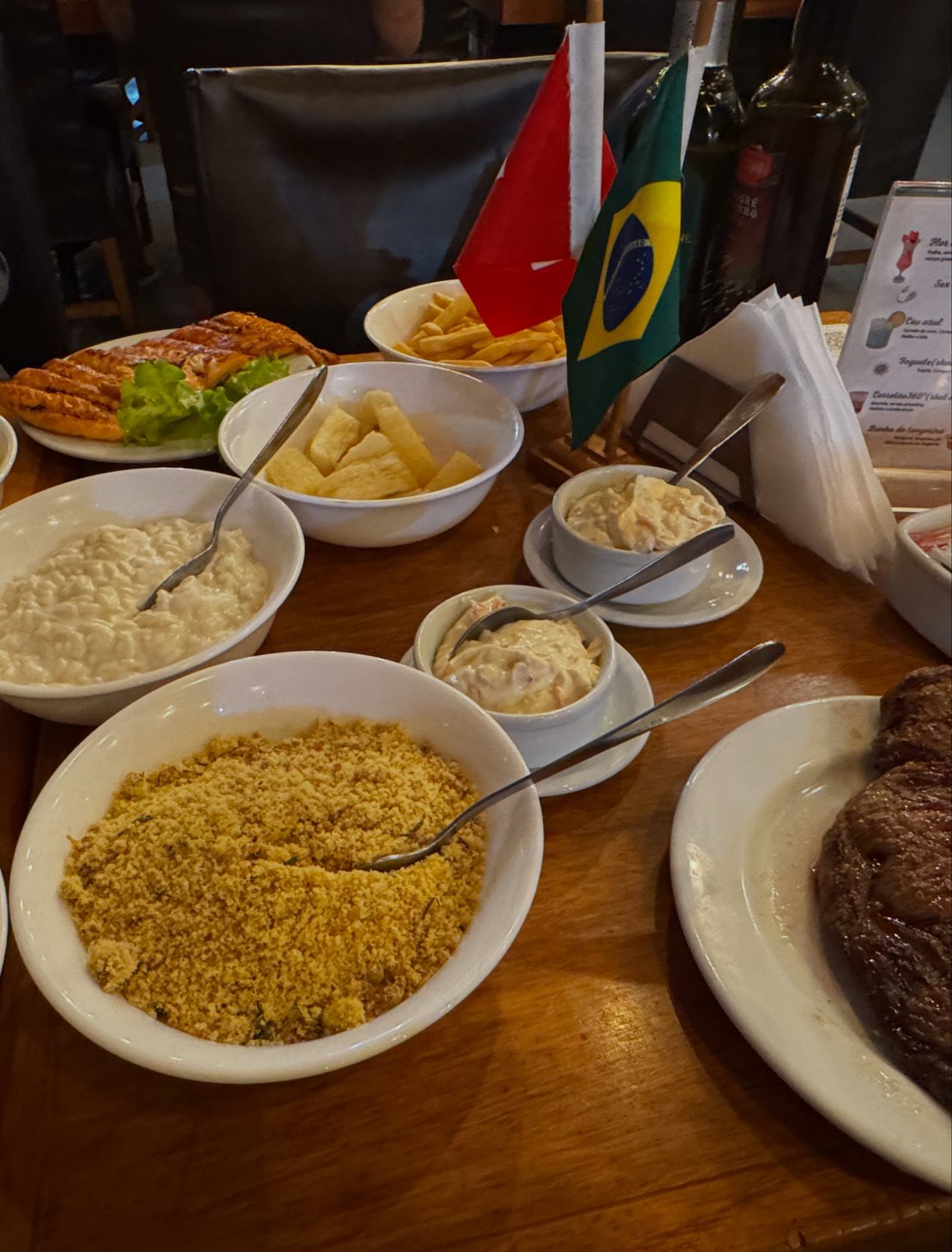 Feijoada, ein brasilianischer Bohneneintopf, mit Beilagen